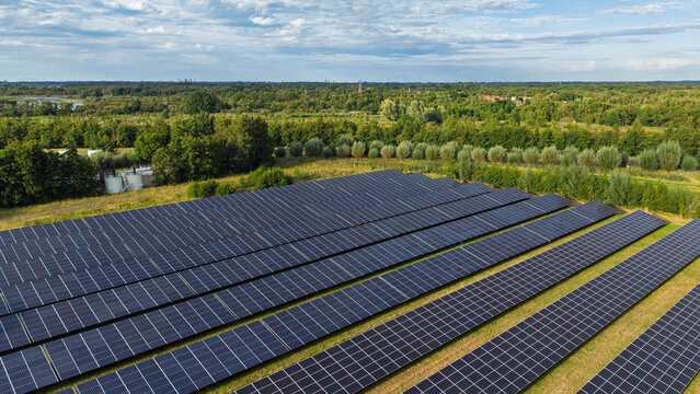 Aerial view of the solar farm at Waterschap Amstel, Gooi en Vecht - RWZI Horstermeer with rows of photovoltaic panels set in a green landscape in Nederhorst Den Berg, Noord-Holland, Netherlands.