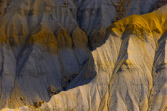 Aerial view of the eroded slopes and sharp ridges of Factory Butte in the desert badlands of Wayne County, Utah, United States.
