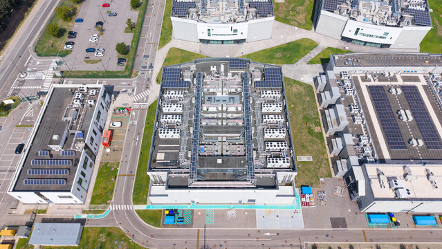 Aerial view of DATA4 MILAN CAMPUS featuring modern data center buildings with rooftop solar panels and HVAC units, surrounded by parking lots in Zona Industriale, Lombardia, Italy.
