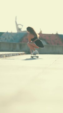 Young athletic woman longboarding in skatepark