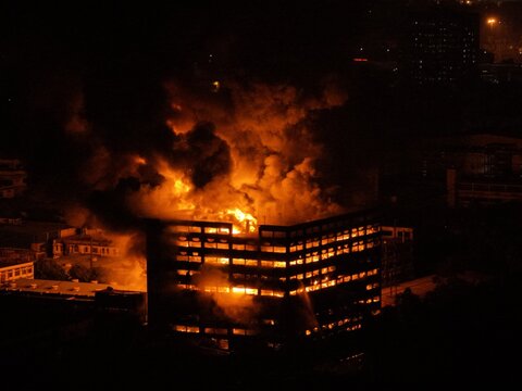 Aerial view of a large industrial building engulfed in flames at night with thick smoke rising from the structure at Chattogram EPZ in Chittagong, Chittagong Division, Bangladesh.