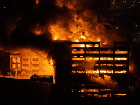Aerial view of a large industrial building at Chattogram EPZ engulfed in intense flames and thick smoke during the night in Chittagong, Chittagong Division, Bangladesh.