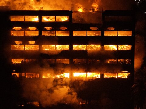 Aerial view of Chattogram EPZ engulfed in a massive fire at night with flames visible through the windows of the industrial building in Chittagong, Chittagong Division, Bangladesh.