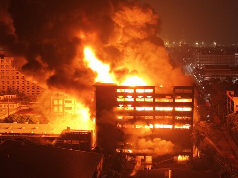 Aerial view of a large building engulfed in intense flames and thick smoke at night within the Chattogram EPZ in Chittagong, Chittagong Division, Bangladesh.