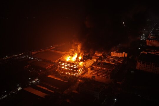 Aerial view of a large industrial building engulfed in flames at night within the Chattogram EPZ in Chittagong, Chittagong Division, Bangladesh.