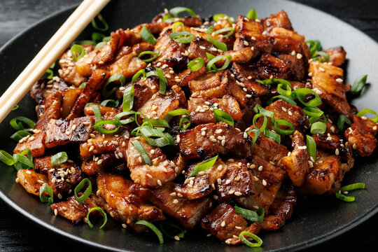 Korean Pork Belly with Sesame Seeds and Green Onions on Black Plate