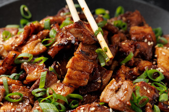 Korean Pork Belly with Sesame Seeds and Green Onions on Black Plate