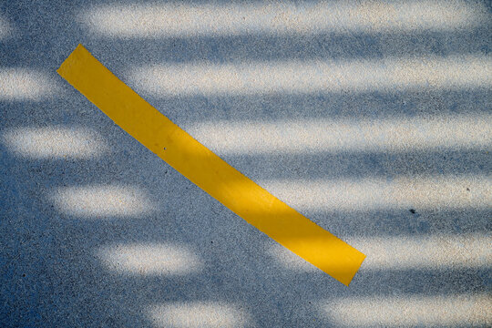 Close-up of a yellow line painted on an asphalt pavement.