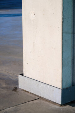 Close-up of the base of a concrete pillar in a large public building.