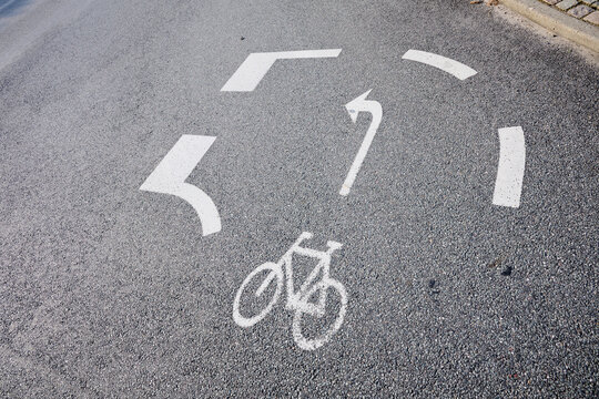 Close-up of a bike lane with a sign indicating a left turn is mandatory.