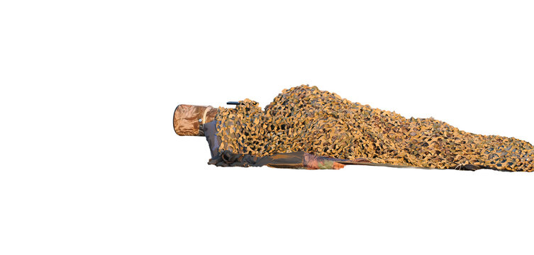 A photographer lying on the ground, isolated against a transparent background and hidden beneath a camouflage net, taking photos of wildlife and birds. The concept of a photo ambush.