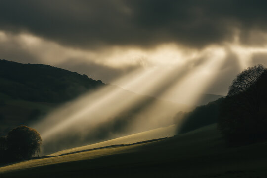 landscape with dramatic sunbeams breaking through dark clouds onto rolling hills, photorealistic