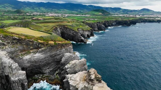 Rocky headland on the Atlantic coast of Sao Miguel Island, Azores, Portugal. Volcanic cliffs and exposed rock formations shape the rugged island shore