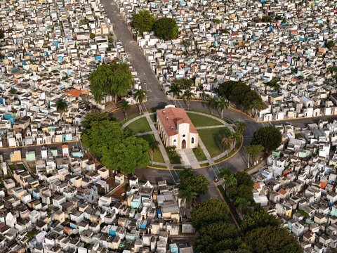 Aerial view of Maximo Gomez National Cemetery with a central chapel, dense rows of tombs, and palm trees in Santo Domingo, Distrito Nacional, Dominican Republic.