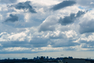 Fototapeta premium Dramatic dark storm clouds gathering dramatically over a silhouette city skyline, creating an intense and moody weather atmosphere. 