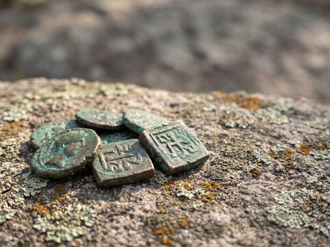 Ancient Bronze Coins and Artifacts Discovered on Mossy Stone Surface, Archaeological Find Concept