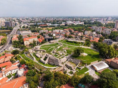 Aerial view of the ancient ruins of Nebet Tepe surrounded by green grass and historic urban architecture in Plovdiv, Plovdiv, Bulgaria.