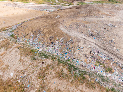 Aerial view of a large landfill site with heavy machinery working on mounds of waste and dirt in Varna, Varna, Bulgaria.