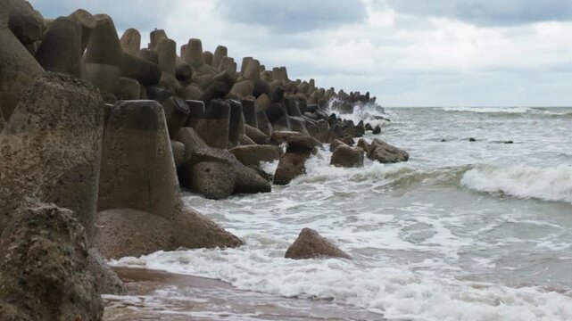 Ocean waves crashing on concrete breakwater tetrapods