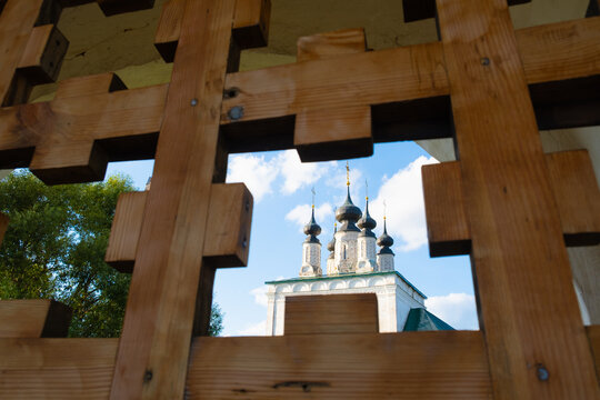 View of the historic orthodox church domes through a carved wooden lattice in Suzdal, Russia. traditional restoration preserves cultural heritage.