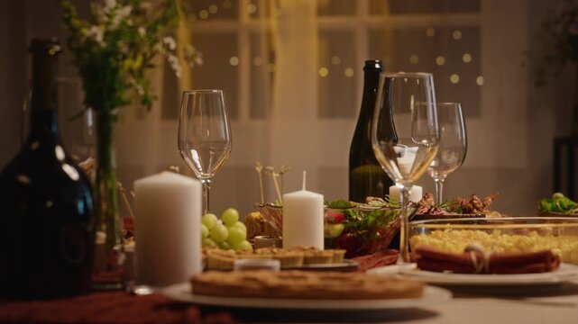 Festive Thanksgiving dinner table standing decorated with holiday dishes, wine glasses, and candles. Footage suitable for seasonal promotions, holiday advertising, and family feast campaigns