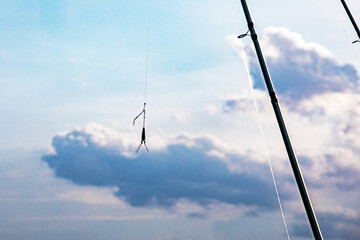 A float on a fishing rod against the sky. Sea fishing. © Oleksandr Davydenko