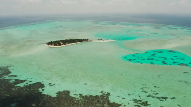 Tropical island with beautiful beach, palm trees and turquoise water view from above. Onok Island, Balabac, Philippines. Summer and travel vacation concept