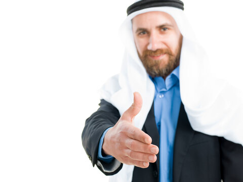 Arab businessman wearing keffiyeh offering hand for a handshake isolated on white background.