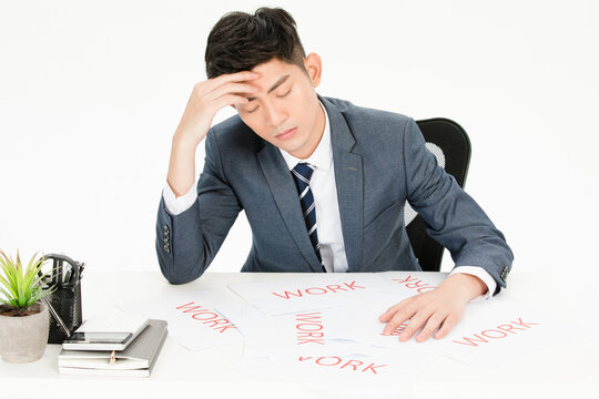 Stressed businessman at desk overwhelmed by work and fatigue