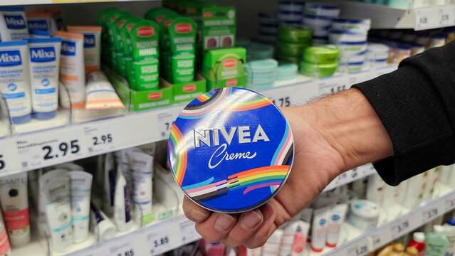 Hand holding nivea creme with rainbow flag design