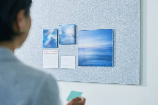 Streaming services concept layout with a Japanese woman standing by a grey acoustic panel wall, featuring blank templates for mockup and copy space