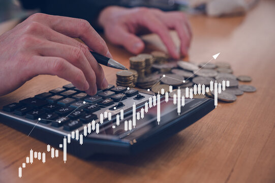 Investment and finance concept, businessman using calculator and stacking coins with virtual chart, stock market, profits and business growth.