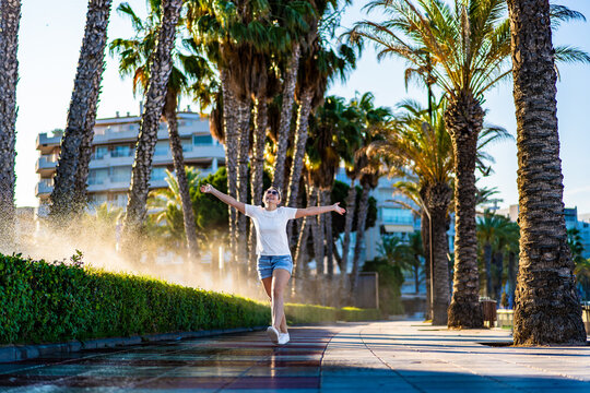 Mid-adult woman walking on seaside boulevard - Costa Dorada Spain
