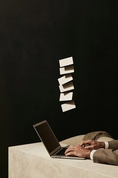 Column of floating payment cards above a laptop, with hands typing on a pale stone desk for holiday travel booking and trip planning mockup