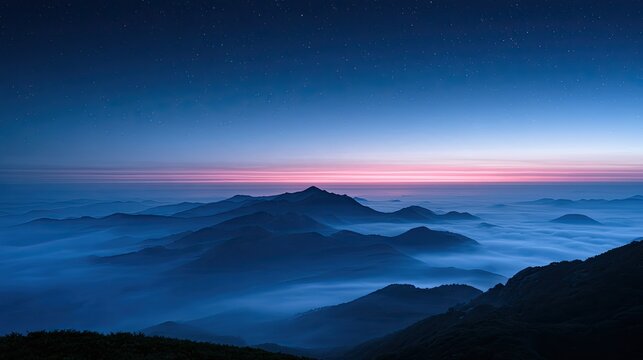 Vast misty mountain ranges under a twilight sky with distant stars