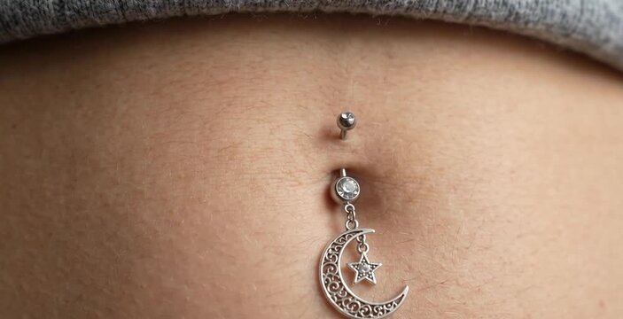 Macro Close Up of Woman Navel Belly Button with Silver Crescent Moon Star Piercing