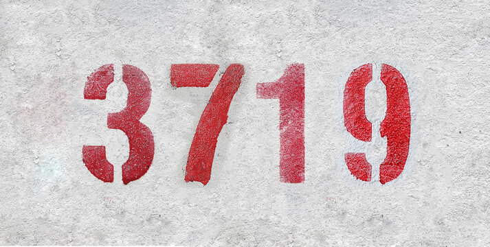 red spray-painted number 3719 sprayed onto a white wall.