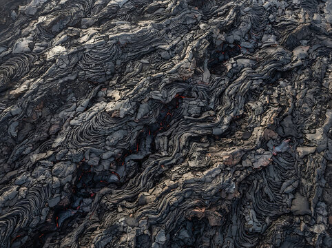 Textured Cooling Basaltic Lava Flow Surface with Glowing Magma Cracks and Rugged Volcanic Rock Formation