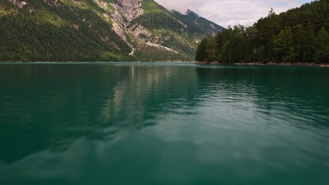 Aerial drone view of Achensee lake in Tyrol, Austria, showing the alpine lake surrounded by mountains and forested shoreline