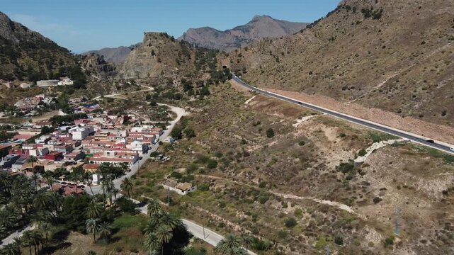 Drone footage of the N340 road passing through the iconic Orihuela palm grove next to San Anton neighborhood in Alicante, Spain. Scenic aerial video.