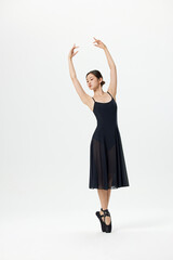 Young ballerina in black dress posing en pointe in studio © LuuNhan