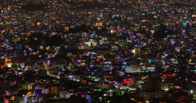 Kathmandu, Nepal, drone shot of the densely populated city valley with vibrant house decorations and colorful urban lights during the annual Tihar festival of lights.