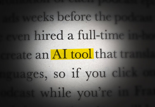 Close up of text highlighting the phrase AI tool in yellow marker on paper with spotlight effect isolated background