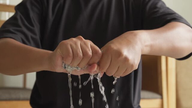 Person wringing a cleaning rag during household cleaning