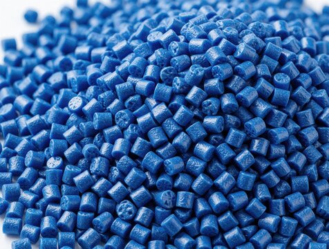 Bright blue plastic pellets heap. Raw material for manufacturing goods. Industrial polymer granules used in production and recycling processes.