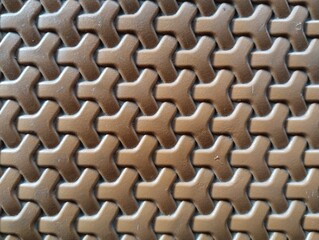 Fototapeta premium Seamless interlocking geometric Y shape pattern on brown plastic surface.