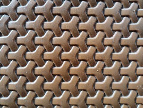 Seamless interlocking geometric Y shape pattern on brown plastic surface.