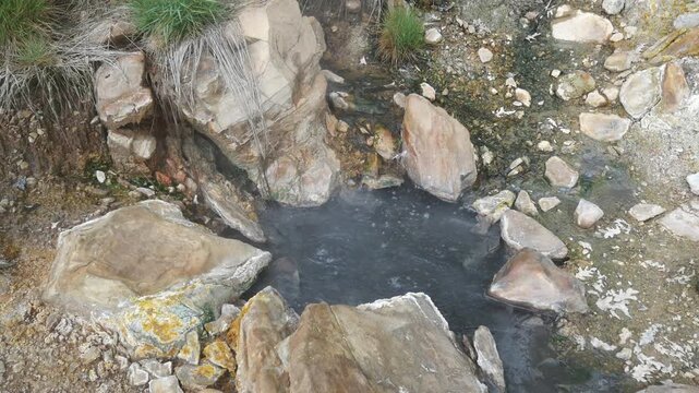 Geothermal springs in Tuscany, Italy, with mineral-rich rocks, steaming ground, and vivid green thermal deposits, showcasing volcanic activity, natural energy, and unusual landscape formations
