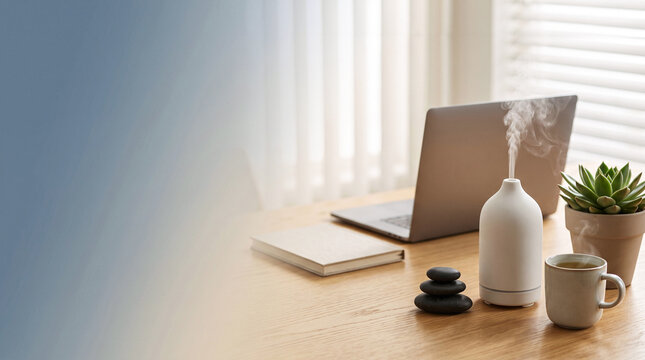 Essential oil diffuser and laptop on office desk for corporate stress relief and workplace wellness.