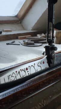 Vertical video: Panning shot revealing sword with engraved symbols, red insets on sill